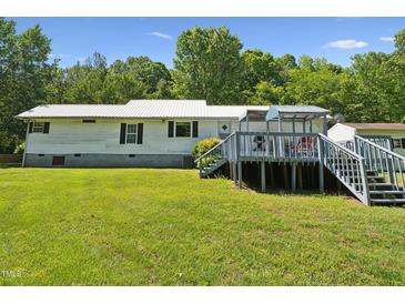 Charming single-story home with a spacious deck and a lush green lawn at 8089 Crawford Currin Rd, Oxford, NC 27565