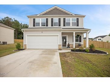 Charming two-story home with gray siding, black shutters, landscaped yard, and a two-car garage at 95 Buckthorn Dr, Youngsville, NC 27596