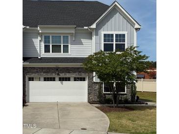 Charming two-story home featuring a gray exterior, stone accents, and an attached two-car garage, set against a blue sky backdrop at 1021 Benay Rd, Morrisville, NC 27560