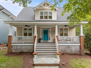 Charming two-story home featuring a welcoming front porch, a bright blue front door, and meticulous landscaping at 10579 Evergreen Spring Pl, Raleigh, NC 27614