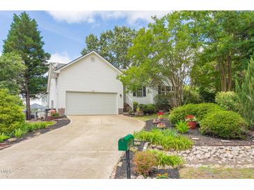 Charming home featuring a two-car garage, well-manicured lawn, and beautiful landscaping at 1113 Pilton Pl, Raleigh, NC 27604