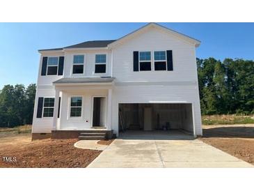 A bright white two-story home featuring black shutters and a spacious two-car garage under a clear blue sky at 120 Cordoba Dr, Franklinton, NC 27525
