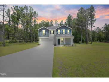 Charming two-story home with beautiful landscaping, long driveway and a welcoming front porch at 124 Teagarden Ct, Sanford, NC 27332