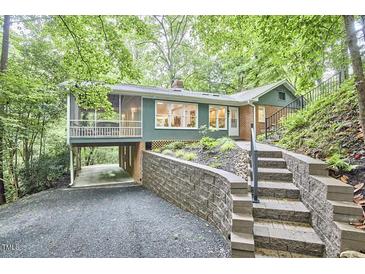 Charming home featuring beautiful landscape, steps leading to front door, a screened-in porch, and covered parking at 126 Weaver Rd, Chapel Hill, NC 27514