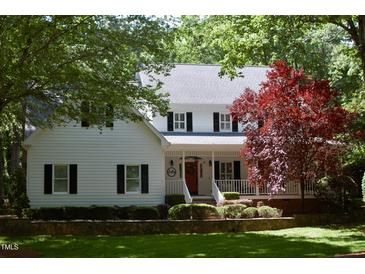 Charming two-story home with a white exterior, black shutters, and a well-manicured front yard at 1300 Keynes Ct, Raleigh, NC 27615