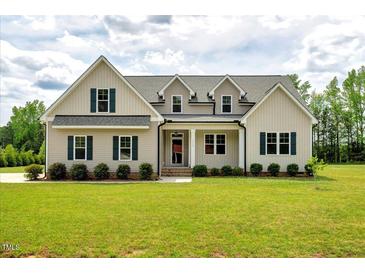 Charming two-story home featuring a manicured lawn and inviting front porch at 1779 Walter Grissom Rd, Kittrell, NC 27544