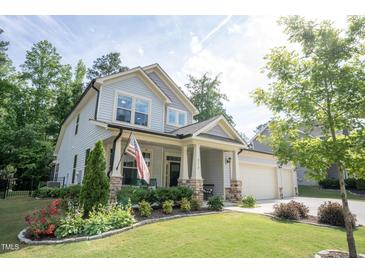 Charming two-story home with an American flag, landscaped yard, and inviting front porch at 212 Hardwick St, Clayton, NC 27527