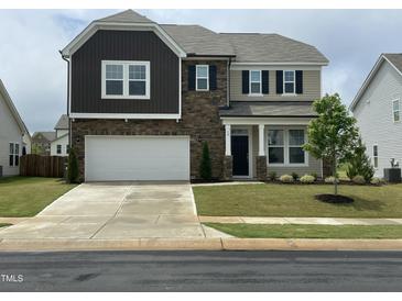 Beautiful two-story home with stone accents, a two-car garage, and manicured landscaping at 30 Junius Birch Trl, Franklinton, NC 27525