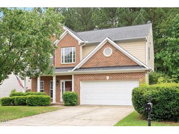 Charming two-story home with brick and siding, manicured lawn, and attached two-car garage at 404 Straywhite Ave, Apex, NC 27539