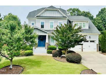 Charming two-story home featuring well-manicured landscaping, a blue front door and an attached two car garage at 4562 Brighton Ridge Dr, Apex, NC 27539