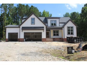 New construction showcasing the exterior elevation of a white home with an open garage at 5900 Tranquil Cv, Youngsville, NC 27596