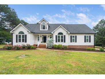 Charming home with a well-manicured lawn, beautiful landscaping, and classic architectural details at 6737 Vernie Dr, Raleigh, NC 27603