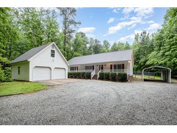 Charming home featuring a large front yard, a detached two-car garage, and an attached carport at 7603 Nichols Dr, Rougemont, NC 27572