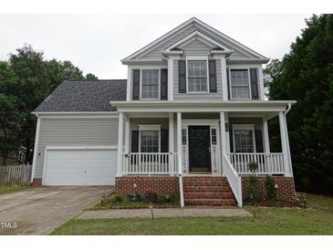 Charming two-story home with a welcoming front porch and well-maintained landscaping at 114 Calebra Way, Cary, NC 27519