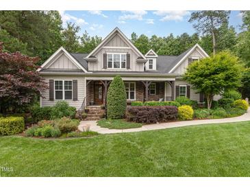 Charming craftsman home with stone accents, a welcoming front porch, and lush landscaping at 114 Margaret Mann Way, Pittsboro, NC 27312