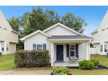 Charming single-story home with blue shutters and a cozy front porch seating area at 1506 Golden Bell Dr, Raleigh, NC 27610