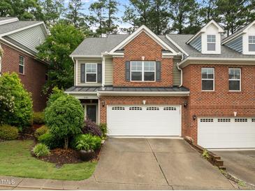 Charming two-story townhome featuring a brick and siding facade with a two-car garage and manicured landscaping at 238 Langford Valley Way, Cary, NC 27513