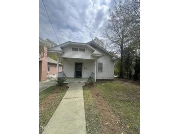 Charming white home with a covered front porch, complemented by a simple, concrete walkway leading to the entrance at 2511 Chapel Hill Rd, Durham, NC 27707