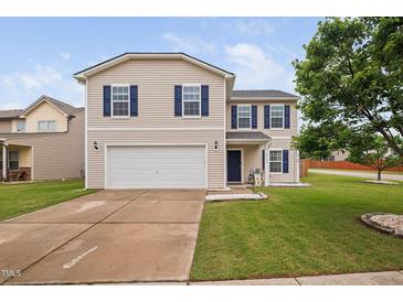 Charming two-story home with a well-manicured lawn, attached two-car garage and blue shutters at 2604 Fortrose Ln, Fuquay Varina, NC 27526