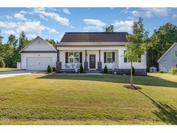 Charming one-story home with a manicured lawn, stone accents, and an inviting front porch at 57 S Shreve Dr, Wendell, NC 27591