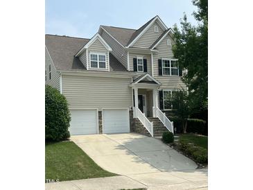 Traditional two-story home featuring a two-car garage, light siding, and manicured landscaping at 609 Redford Place Dr, Rolesville, NC 27571