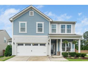 Charming two-story home featuring blue siding, white trim, and a welcoming front porch with rocking chairs at 102 Michelangelo Pl, Morrisville, NC 27560