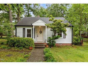Charming home featuring a welcoming front porch and manicured landscaping at 1105 Hawthorne Ln, Burlington, NC 27215