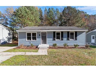 Charming single-story home featuring a light blue exterior, updated windows, and a well-maintained lawn at 1211 Freeman Dr, Sanford, NC 27330