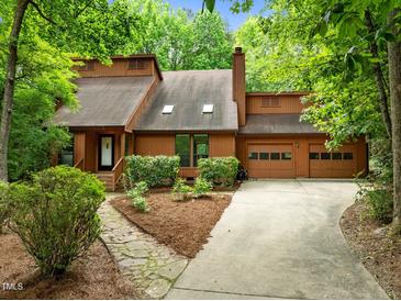 Charming home featuring a two-car garage, manicured front yard, and inviting stone walkway at 122 Blackcherry Ln, Chapel Hill, NC 27514