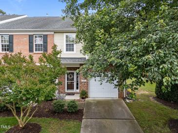 Charming brick and siding townhome featuring a one-car garage and well-maintained landscaping at 2950 Settle In Ln, Raleigh, NC 27614