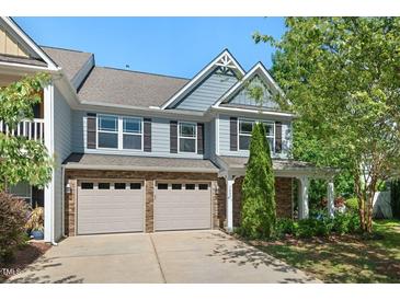 Two-story townhome featuring stone accents, gray siding, and a two-car garage, set against a blue sky at 3002 Bartlett Cir, Hillsborough, NC 27278
