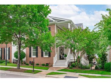 Charming two-story brick home with white trim, black shutters and a well-manicured lawn at 321 Commons Walk Cir, Cary, NC 27519