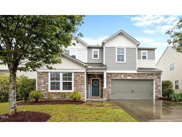 Charming two-story home featuring stone accents, siding, a two-car garage and a welcoming green front door at 4212 Auburn Hills Dr, Raleigh, NC 27616