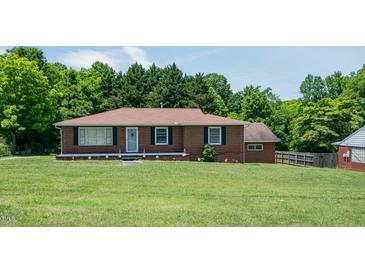 Charming single-story brick home with a well-maintained front yard and mature trees at 424 Camp Rd, Burlington, NC 27217