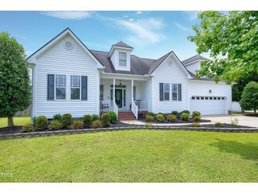 Charming white two-story home with dark shutters, manicured lawn, and beautiful landscaping at 5016 Swordfish Dr, Raleigh, NC 27603
