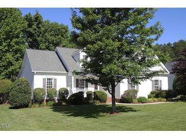 Charming single-story home with well-maintained lawn, mature trees and manicured landscaping at 70 Glen Oaks Drive Dr, Youngsville, NC 27596