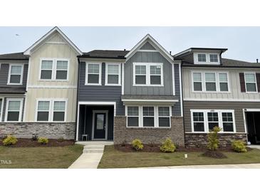 Charming townhome displaying a contemporary design, complemented by neat landscaping and stone accents at 803 Courting St, Apex, NC 27523