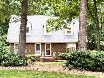 Charming brick home featuring a well-manicured lawn and complemented by mature trees at 8620 Brookdale Dr, Raleigh, NC 27613