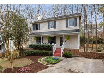 Charming two-story home with a welcoming front porch, red steps and landscaped yard at 905 Balmoral Dr, Cary, NC 27511