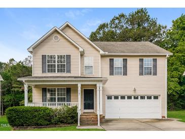 Traditional two-story home with a covered porch, manicured lawn and attached two car garage at 107 Kimeo Way, Garner, NC 27529