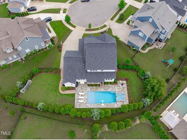 Stunning aerial view of a home featuring a pristine backyard pool and manicured landscaping at 120 Hazel Alder Ct, Holly Springs, NC 27540