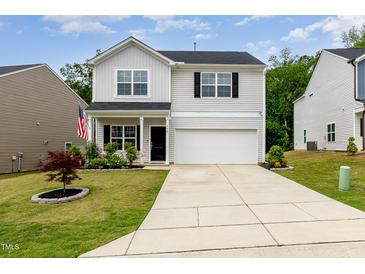 Charming two-story home with landscaped front yard and an attached two-car garage at 150 Sherrill Place Ln, Garner, NC 27529