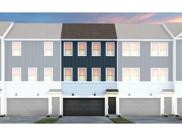 Stylish townhome featuring navy blue accents, a two-car garage, and charming curb appeal at 1517 Tamarisk Ln, Durham, NC 27703