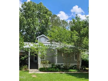 Charming home exterior with a manicured lawn, mature trees, and a welcoming entrance in a desirable neighborhood at 204 Kirkwood Dr, Chapel Hill, NC 27514