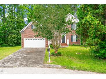 Charming two-story brick home with a well-manicured lawn and an attached two-car garage at 2305 Bryarton Woods Dr, Raleigh, NC 27606