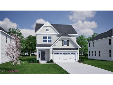 Charming two-story home with a two-car garage, lush green lawn, and traditional architectural details at 264 Meadowbark Bnd # 43, Garner, NC 27529