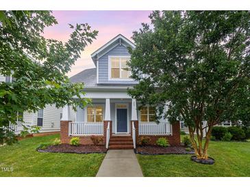 Charming two-story home with a welcoming front porch, manicured lawn, and beautiful landscaping at 307 Millbrook Dr, Pittsboro, NC 27312