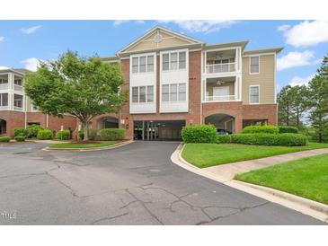 View of the apartment complex featuring parking, balconies, and lush landscaping on a sunny day at 324 Waterford Lake Dr, Cary, NC 27519