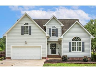 Charming two-story home features a manicured lawn, attached garage, and classic architectural details at 40 Breckenridge Pl, Dunn, NC 28334