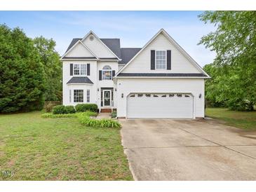 Charming two-story home with a well-manicured lawn and attached two car garage at 5608 Scottish Hills Dr, Holly Springs, NC 27540